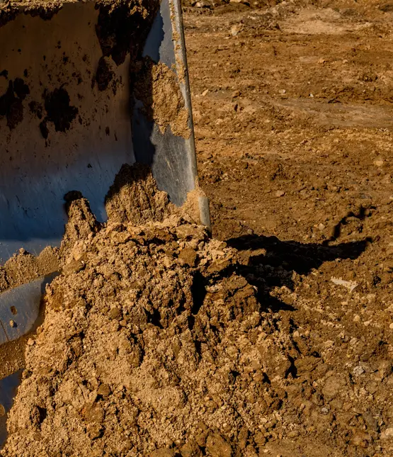 Close-up of a bulldozer blade pushing and grading soil